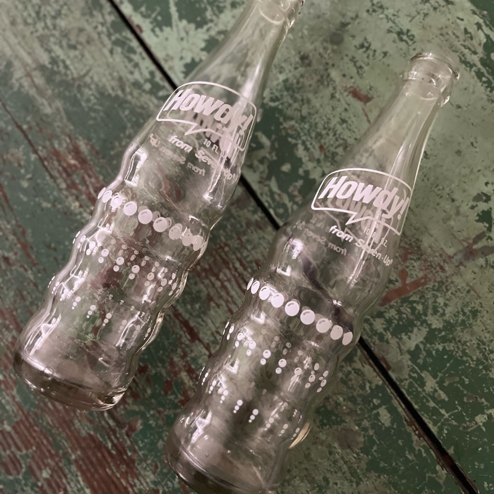 Vintage “ Howdy” soda bottles. A 7-up pruduct